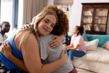 Supportive diverse female friends hugging each other at group therapy session. Therapy, mental health, friendship and support, unaltered. Supportive diverse female friends hugging each other at group therapy session. Therapy, mental health, friendship and support, unaltered.